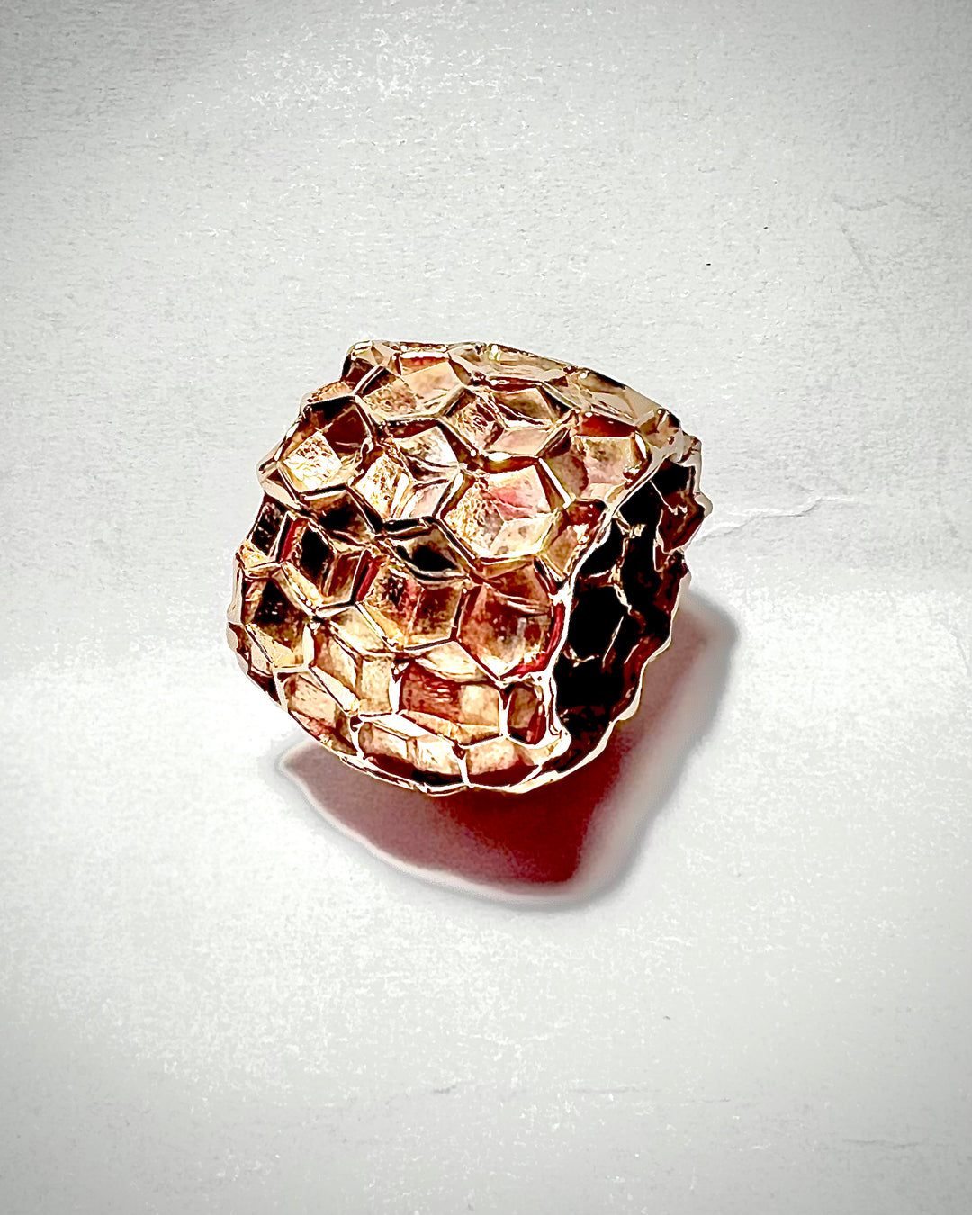 Anello in bronzo lavorato con bassorilievi esagonali che riproducono la forma i un alveare